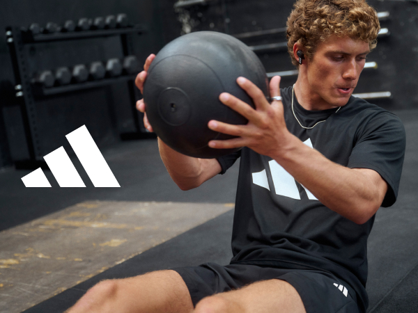 adidas logo and male in the gym working out with a medicine ball