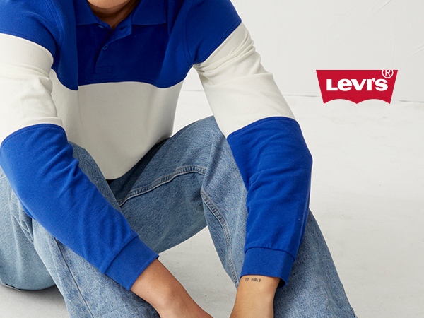 model wearing white and blue striped shirt and levis jeans sitting in front of white background